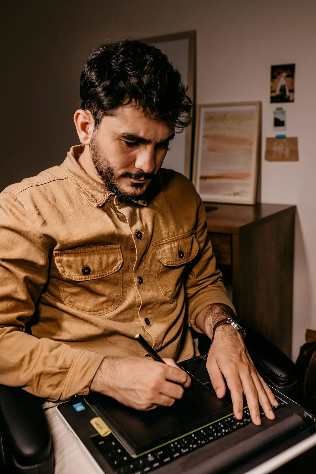 man in brown button up long sleeve shirt holding black smartphone